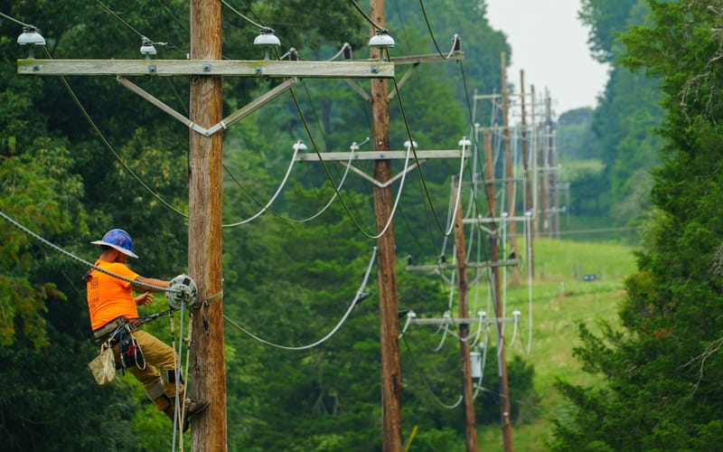 A utility worker installs a fiber internet line. Photo by the US Department of Agriculture.
