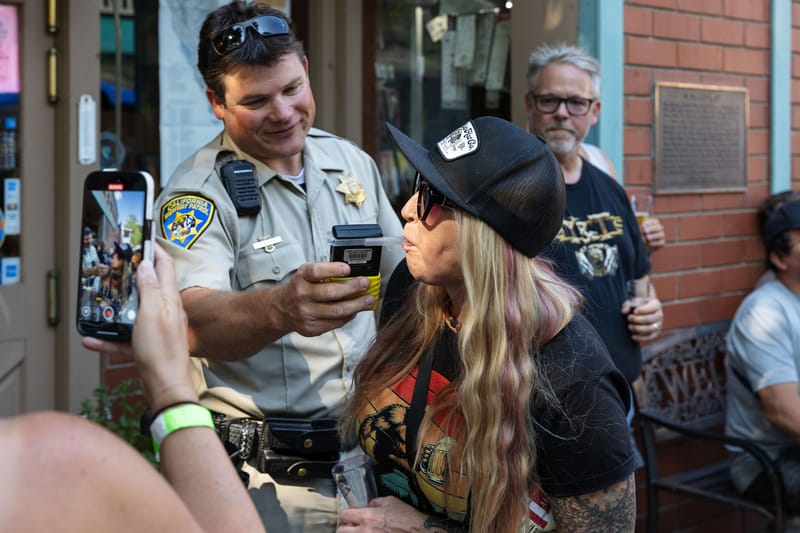 Highway Patrol Officer Kostik administers a breathalyzer test to a 2025 Brewfest attendee.