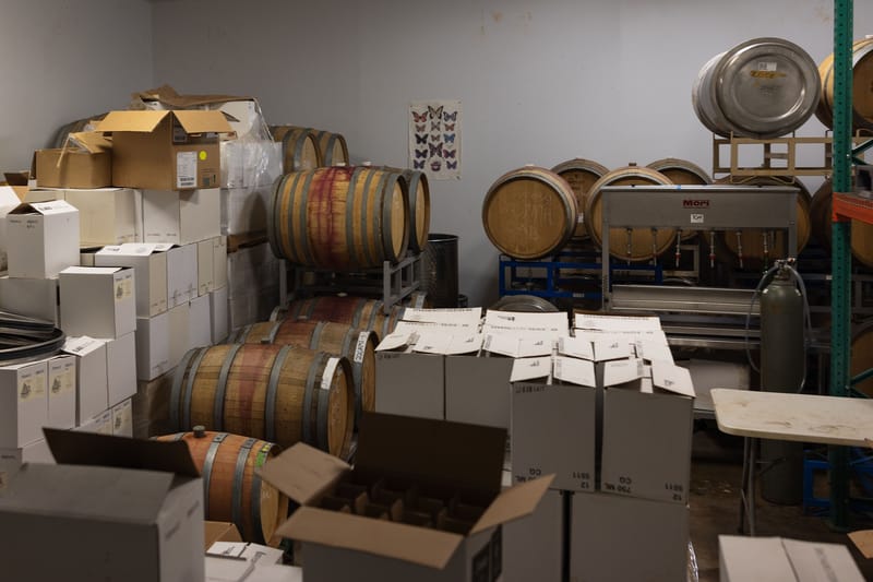 Doolan’s processing facility, including barrels of aging wine and bottles being prepared for shipment.