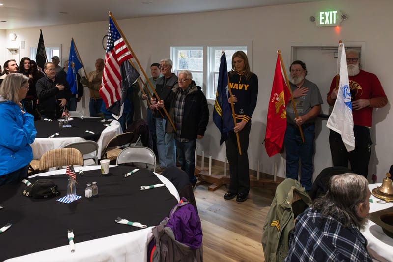 Veterans hold the flags of the United States and branches of the military as the national anthem plays in the Downieville Community Hall